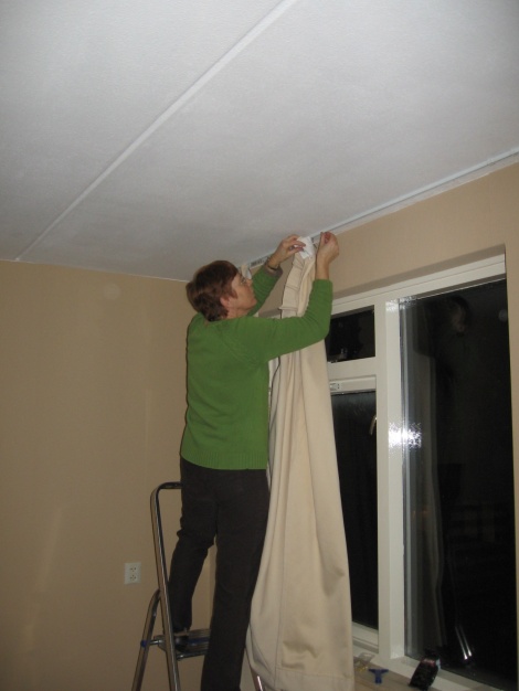 Oma Valk heeft de gordijnen op maat gemaakt en hangt ze op...
